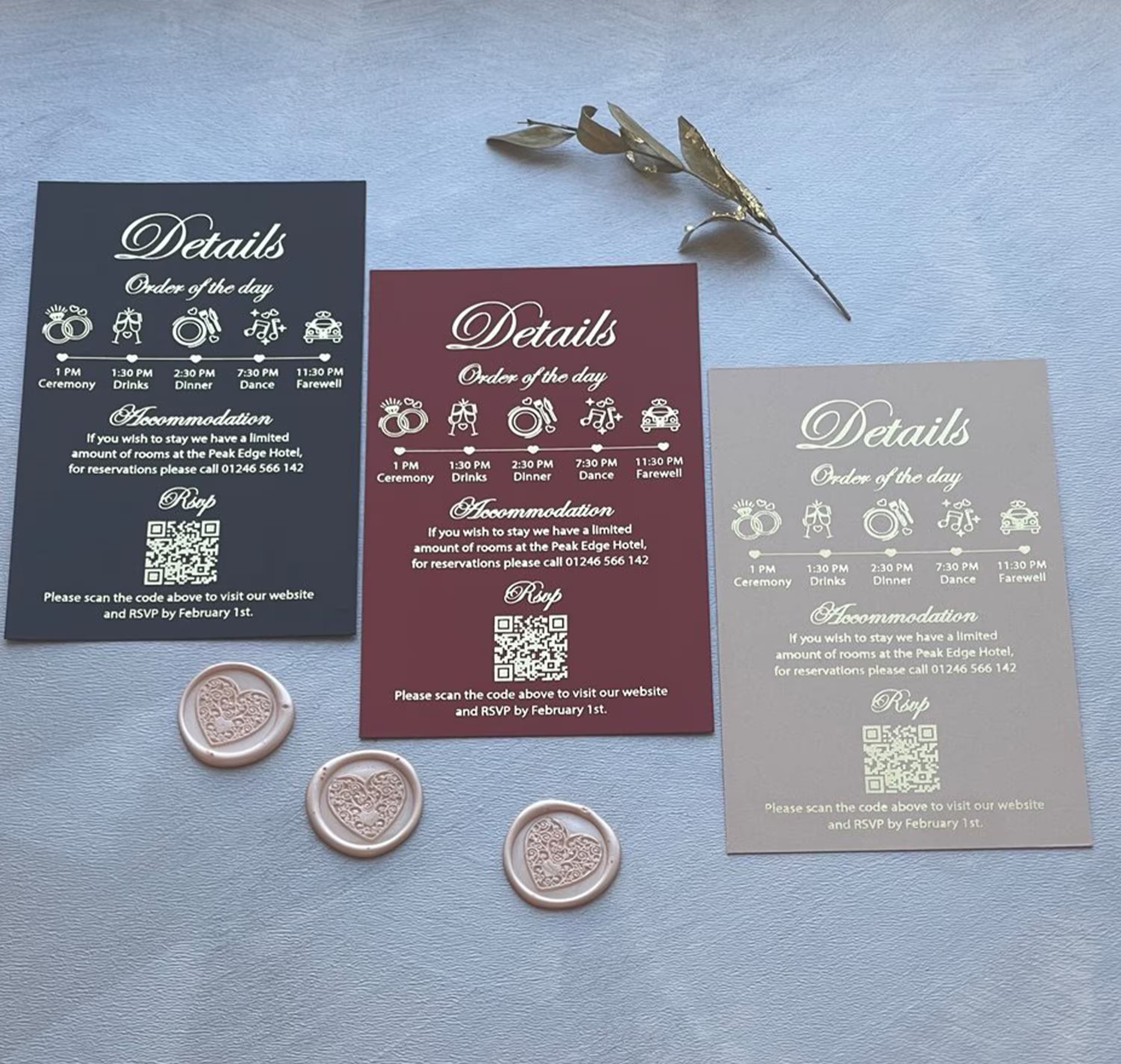Acrylic wedding invitation details cards in navy, burgundy and taupe, each with a foil order of the day timeline and a QR code for online RSVP