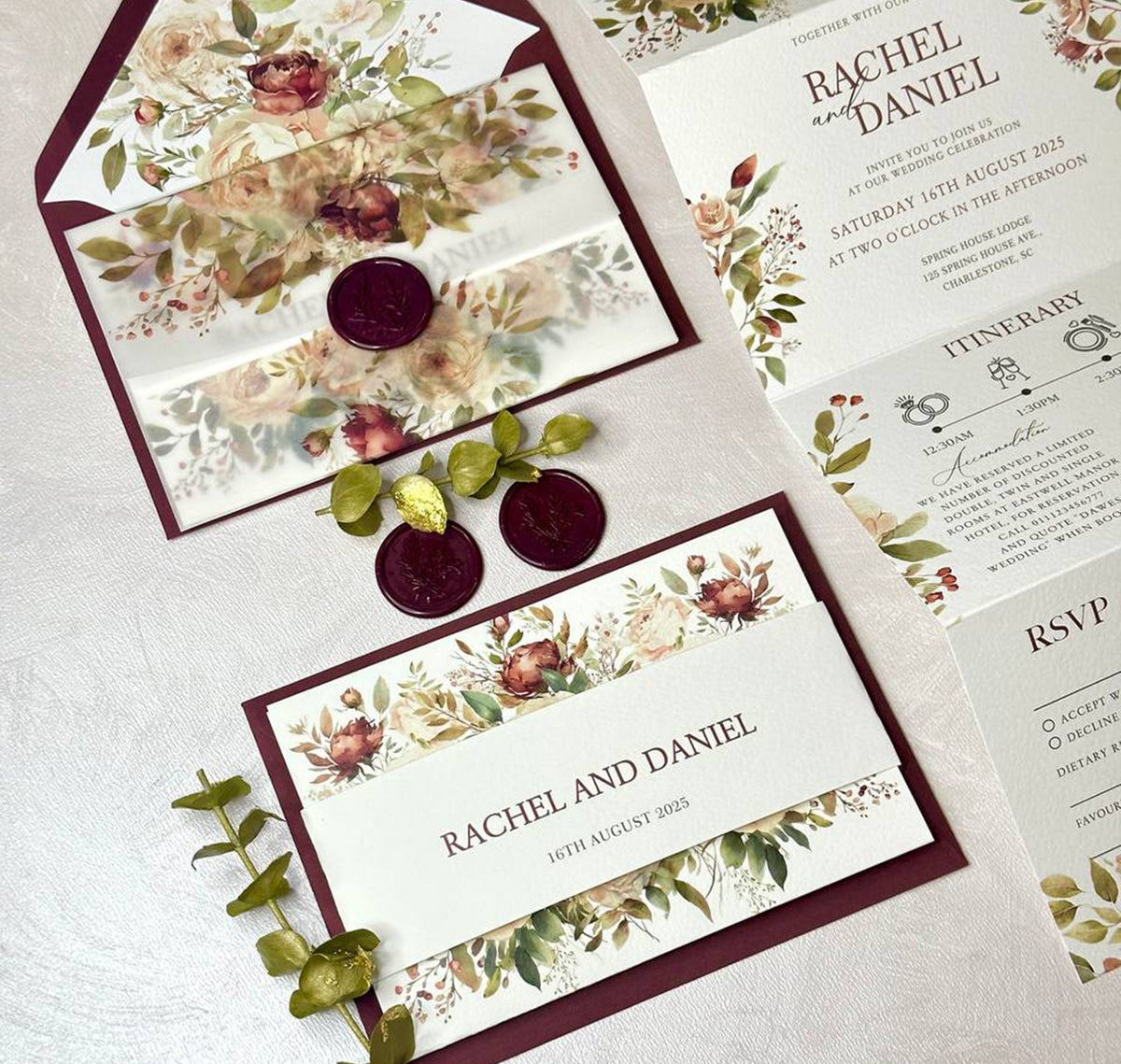 Burgundy floral concertina wedding invitations all in one suite flat lay with envelope, vellum jacket and wax seals