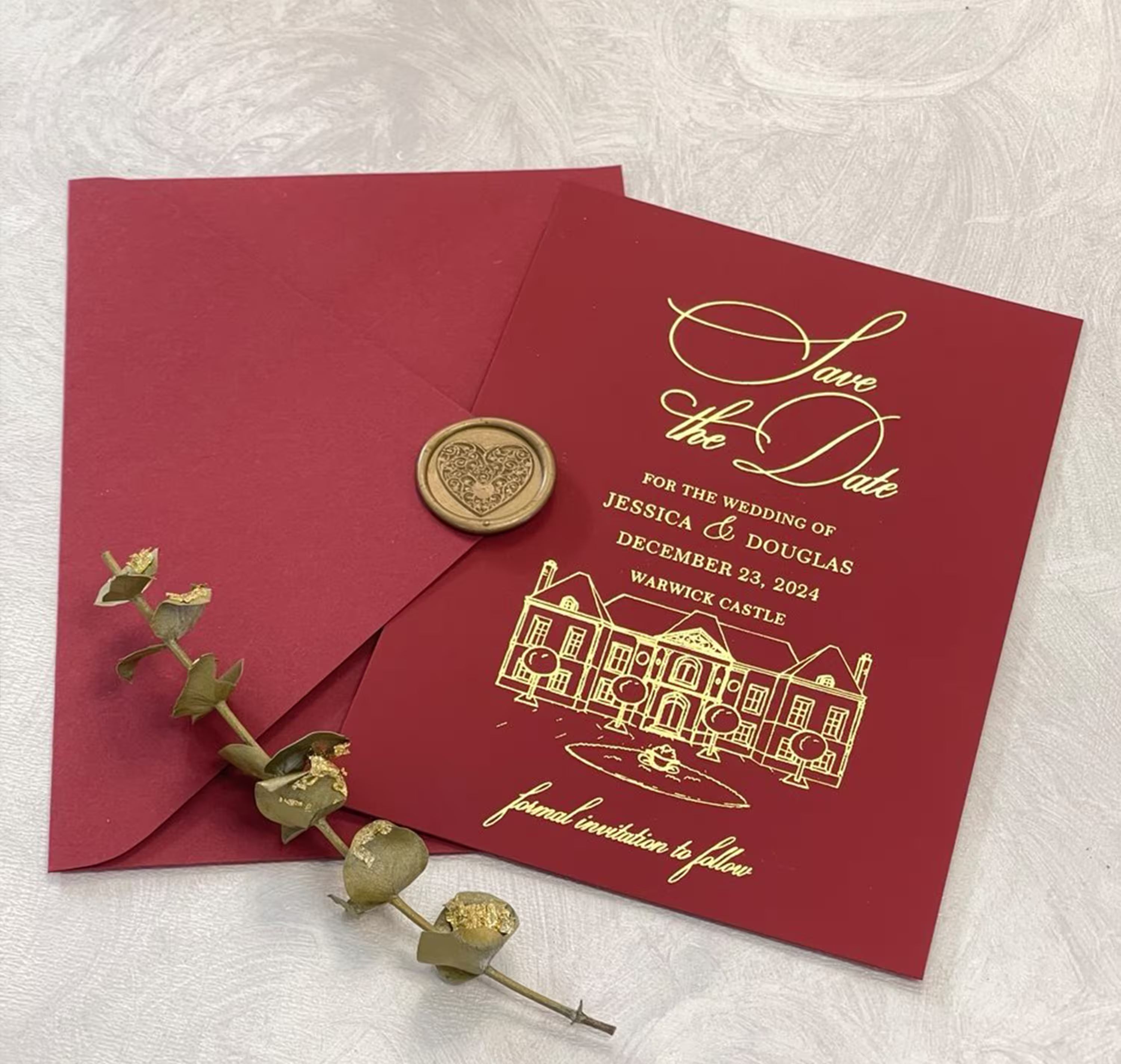 Burgundy Save the Date card featuring custom venue artwork and foil details