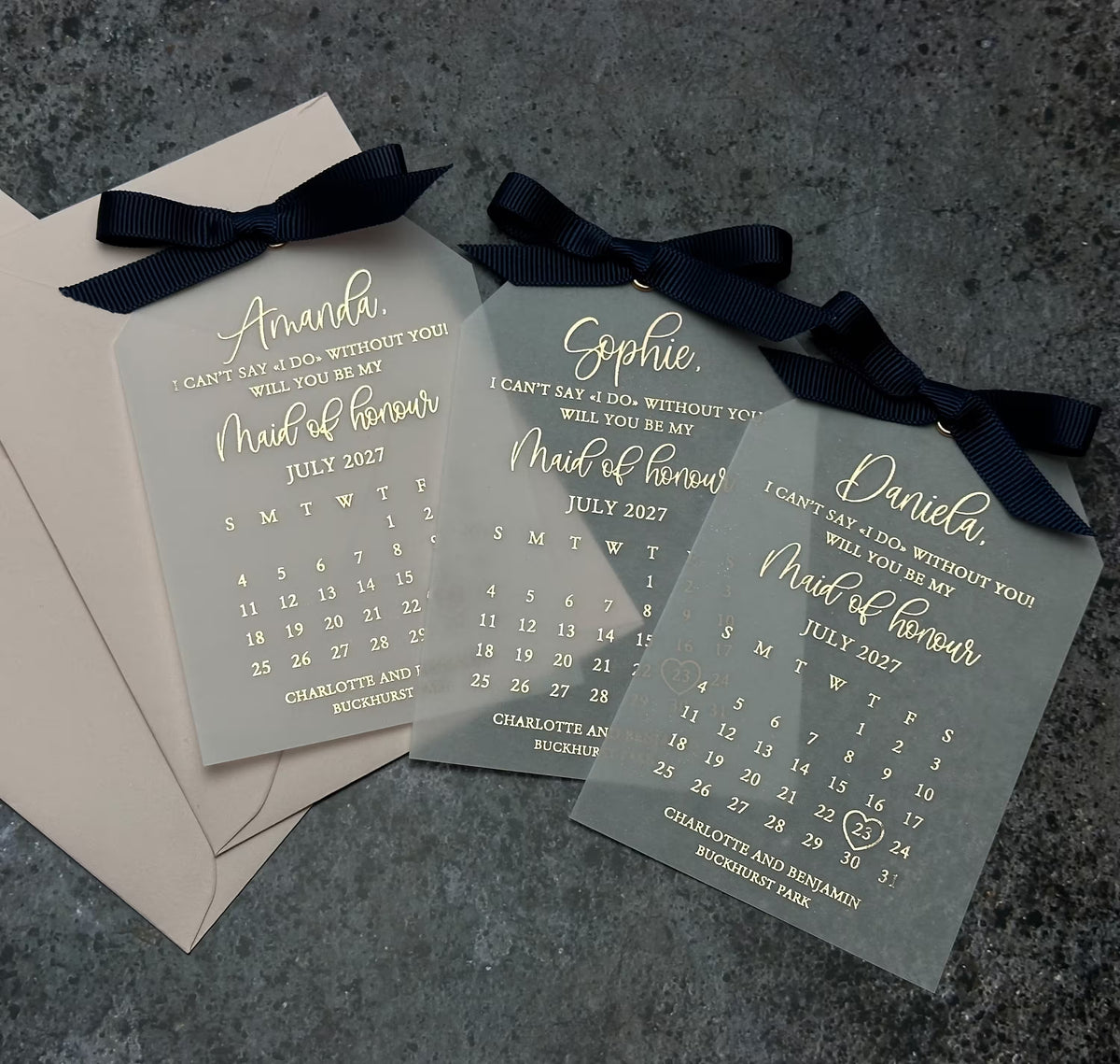 Close-up of elegant foil lettering on a translucent vellum proposal card with a matching ribbon.