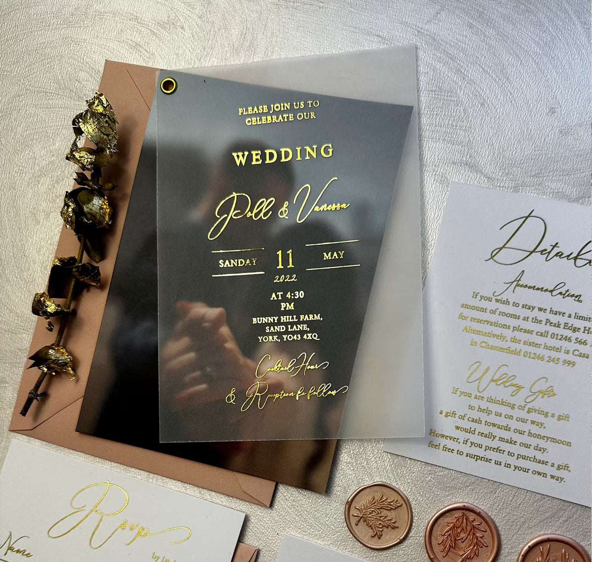 Close up of wedding photo invitation card with couple photo glowing through vellum and personalized foil lettering