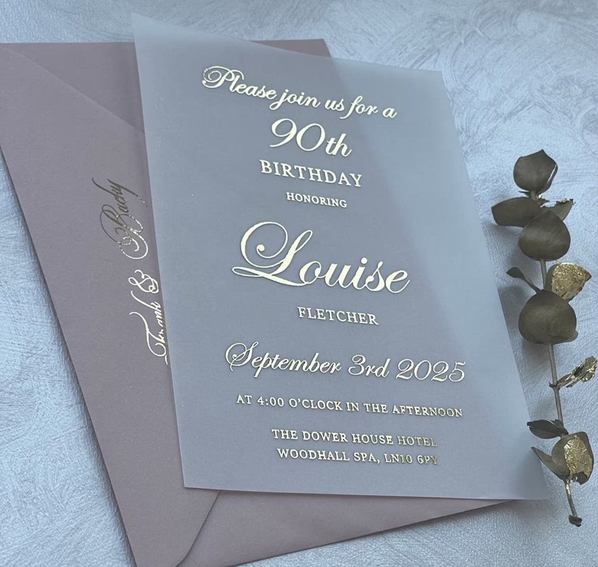 80th birthday invitations on soft vellum with foil lettering, personalized with the name, date and venue.