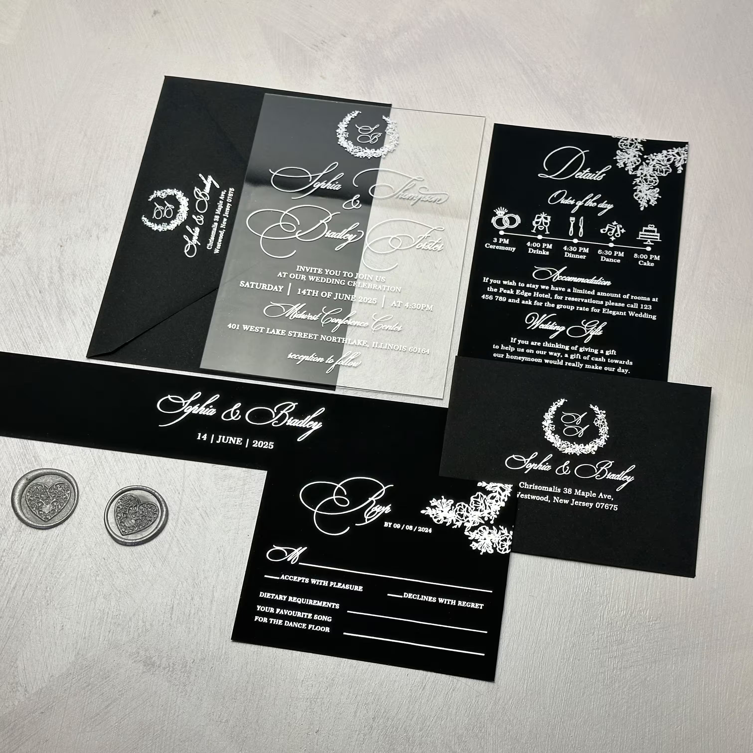 Black wedding invitation suite with a clear acrylic invitation, silver foil monogram wreath and calligraphy, paired with a black envelope, details card, RSVP and belly band