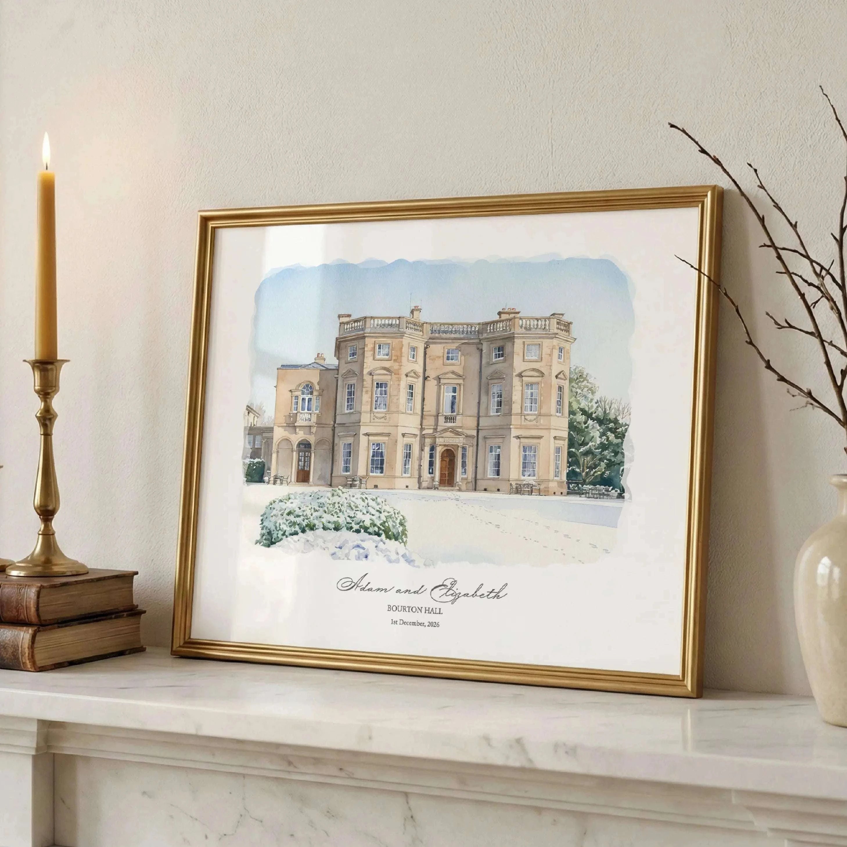 Framed watercolour portrait of Bourton Hall wedding venue in winter, featuring a classical English manor house with delicate snow details and elegant gold frame styling.