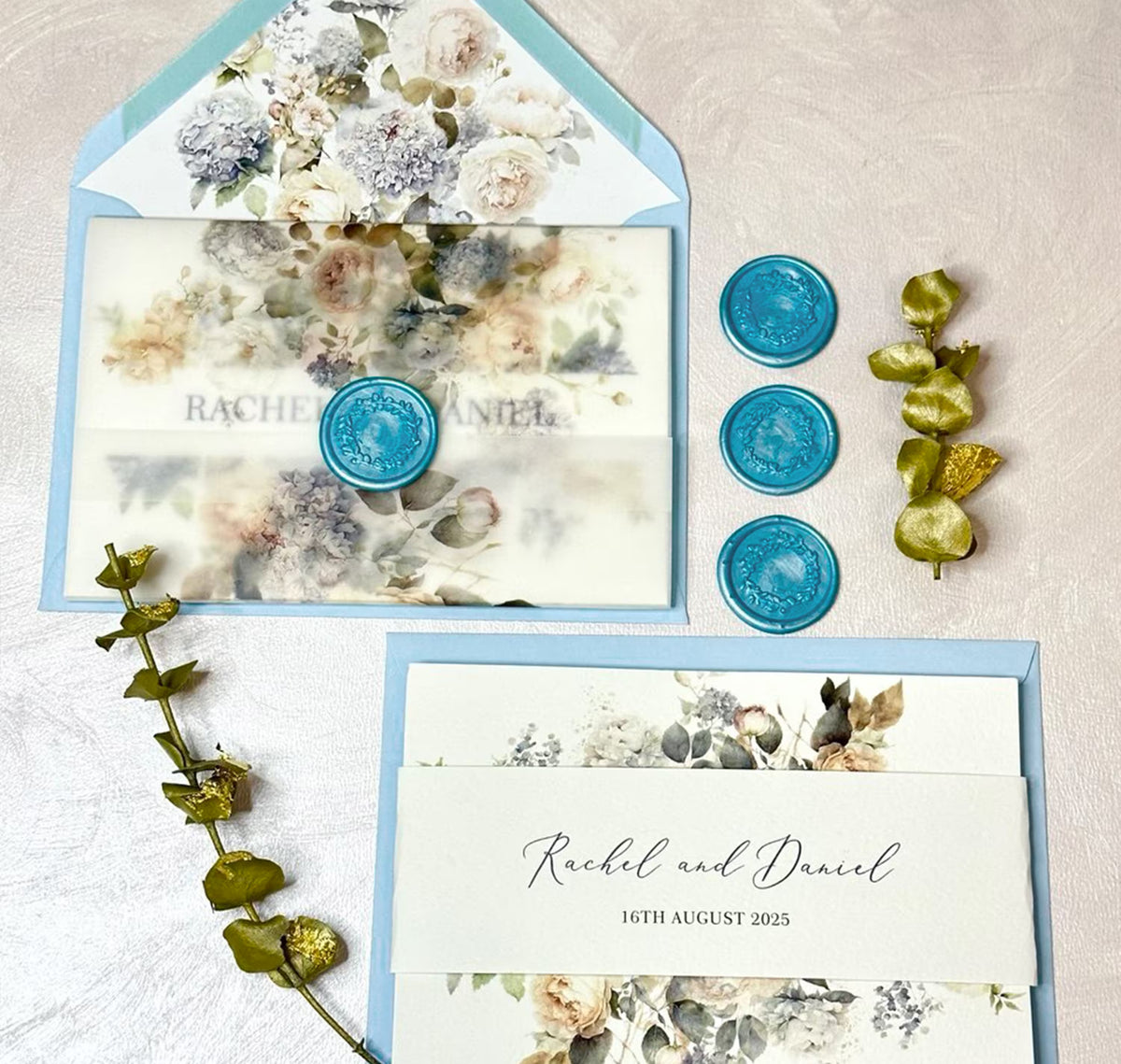 Concertina wedding invitations in dusty blue palette with floral envelope liner and vellum jacket