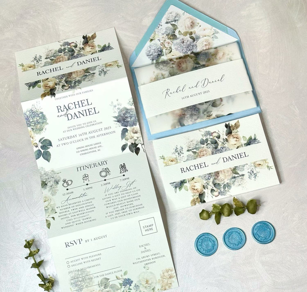 Concertina wedding invitations in dusty blue palette flat lay with envelope, vellum jacket and wax seals
