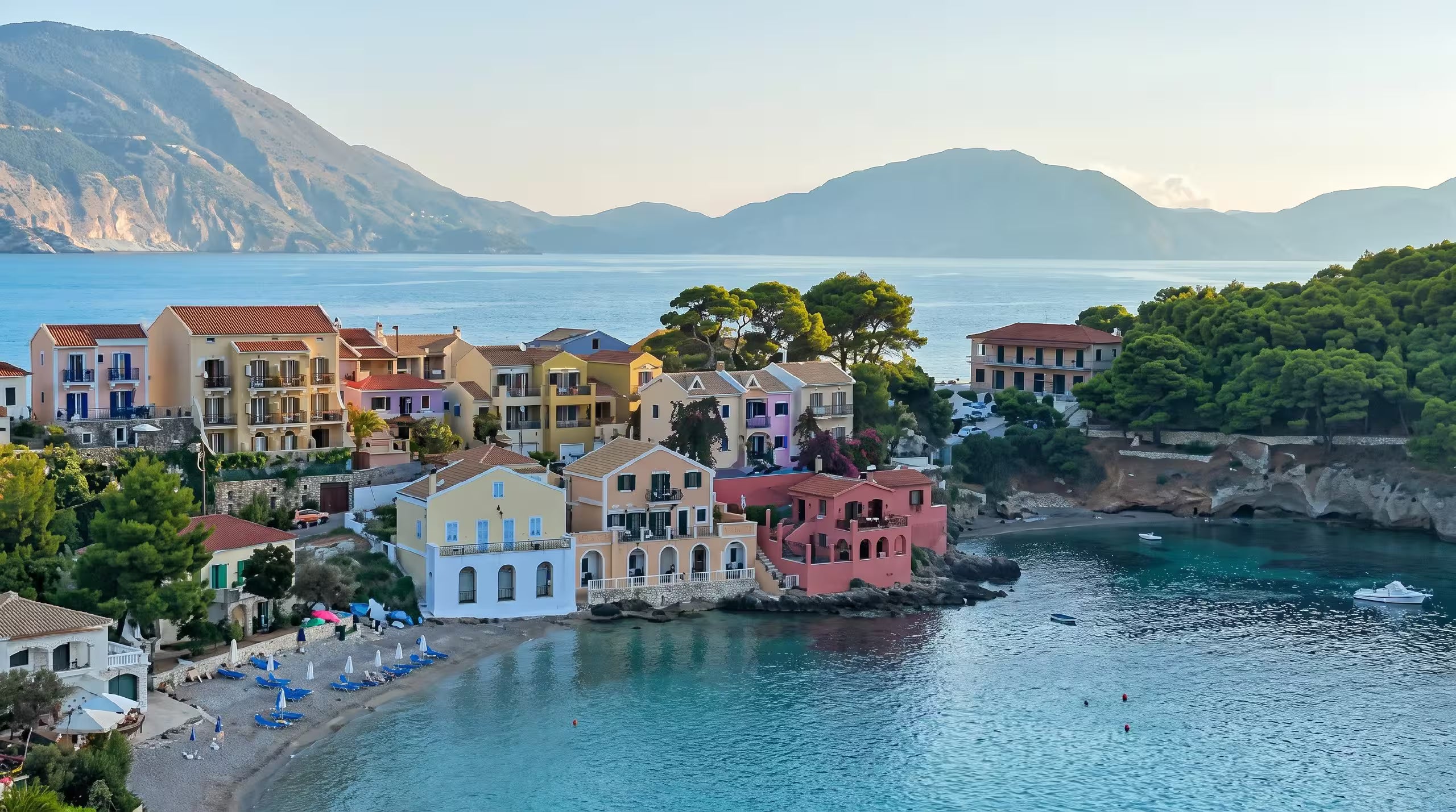 Reference photograph of a colourful Greek coastal village at Assos in Kefalonia, pastel houses around a turquoise bay, the kind of photo a customer sends before a watercolor portrait is created