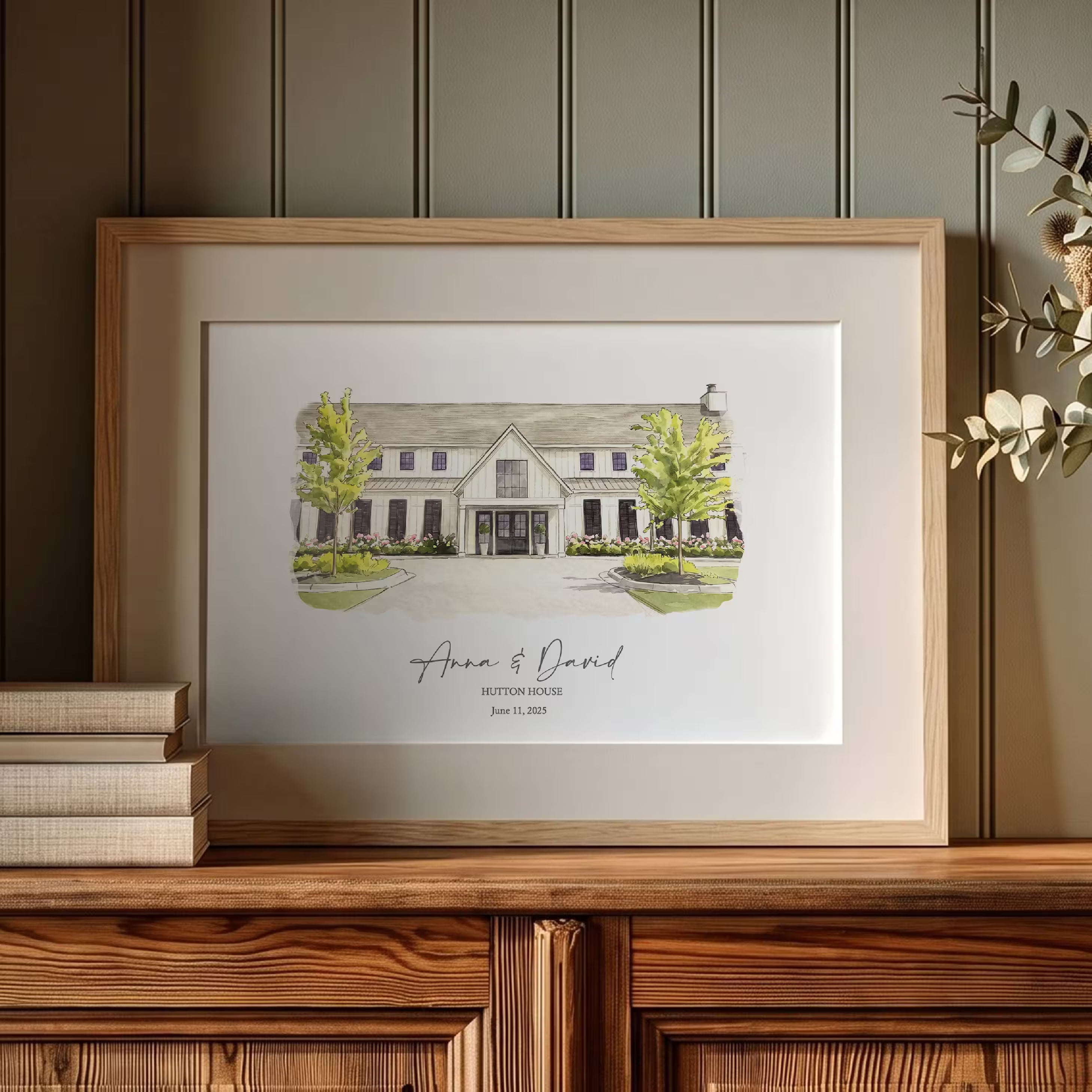 Minimalist watercolor portrait of Hutton House, a white board and batten wedding venue framed by two young trees, in a light oak frame with a white mat. Created from your photo and personalized with the couple names and wedding date, a paper first anniversary gift.