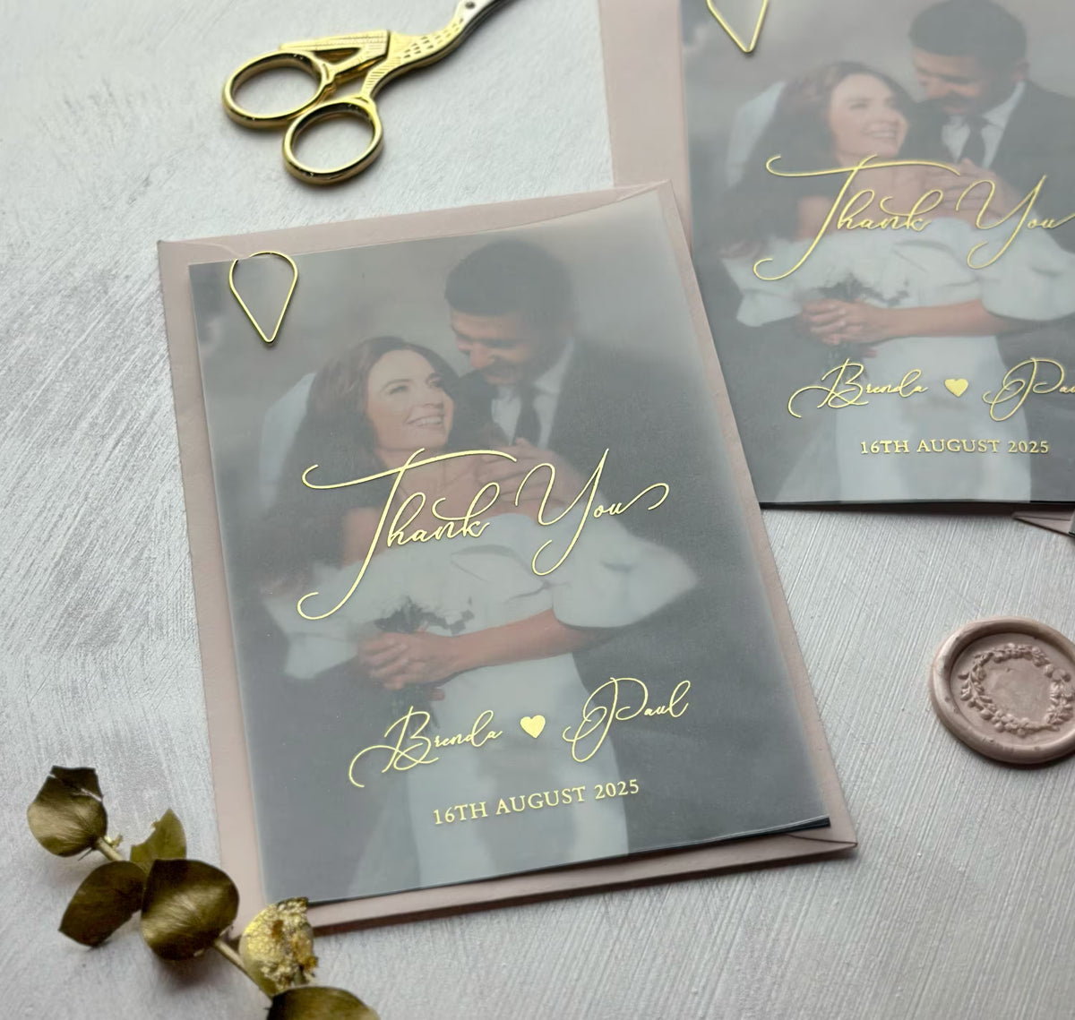 Close up of personalized thank you card with couple photo and foil lettering softly veiled in vellum