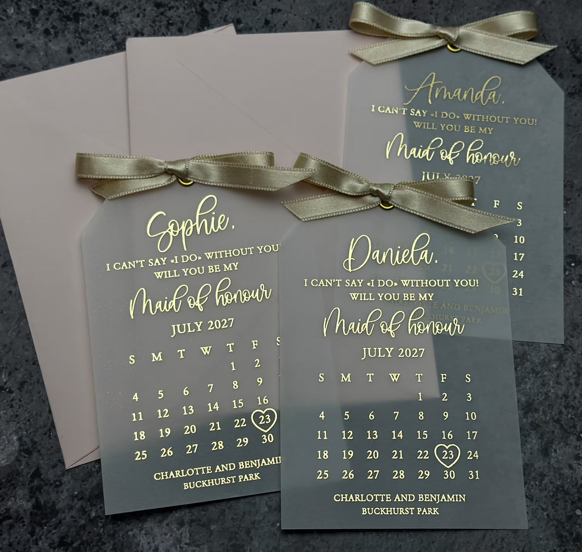 Personalized vellum proposal card with foil lettering, a custom wedding calendar, and a decorative ribbon bow.