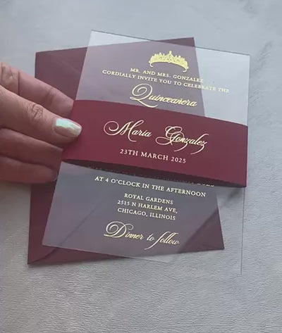 Video of acrylic quinceañera invitations with a foil tiara and script lettering on clear acrylic, personalized quince invitation with a belly band.