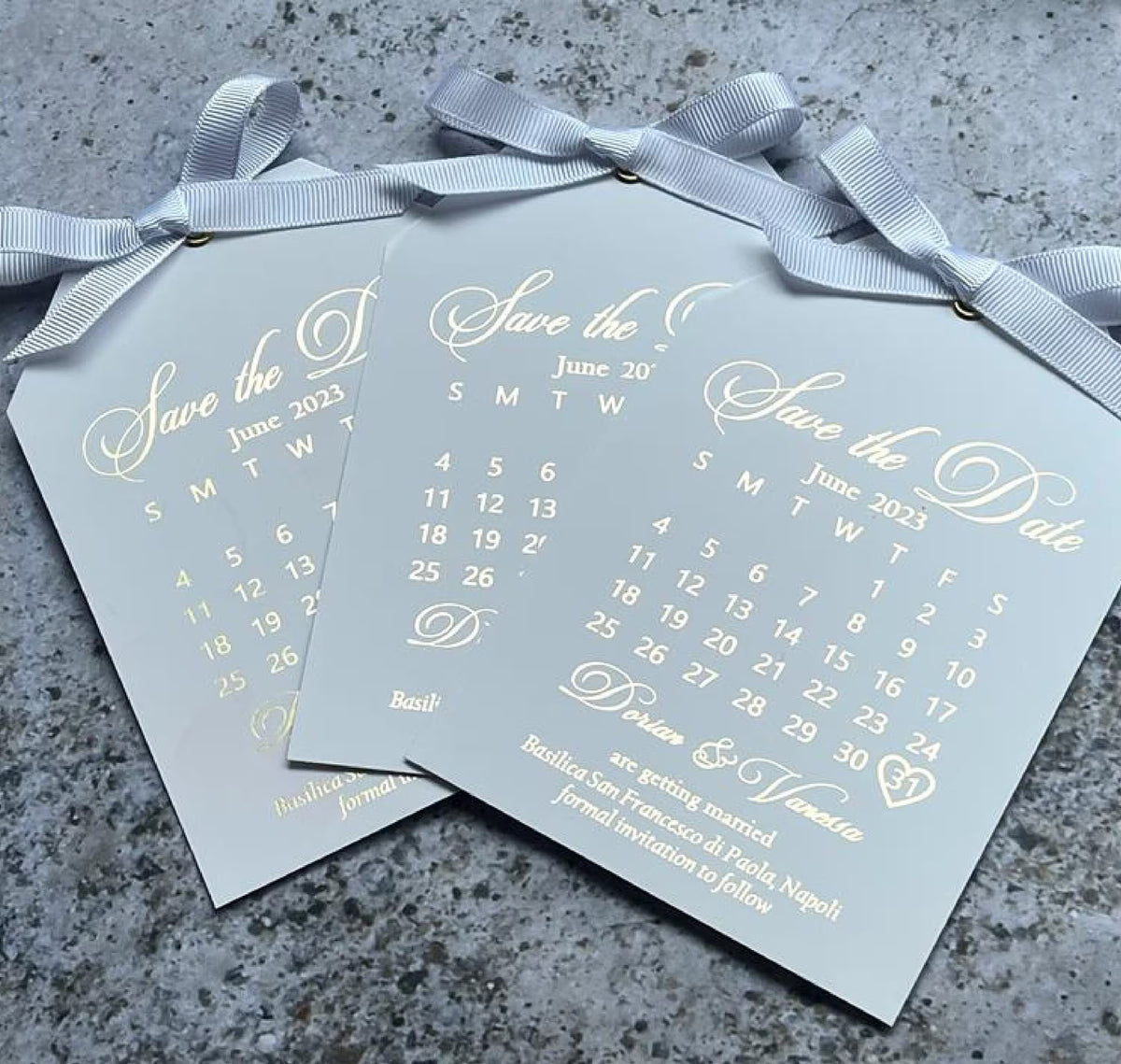 Personalized wedding save the date tag with a foil calendar, tied with a ribbon and shown with an envelope.