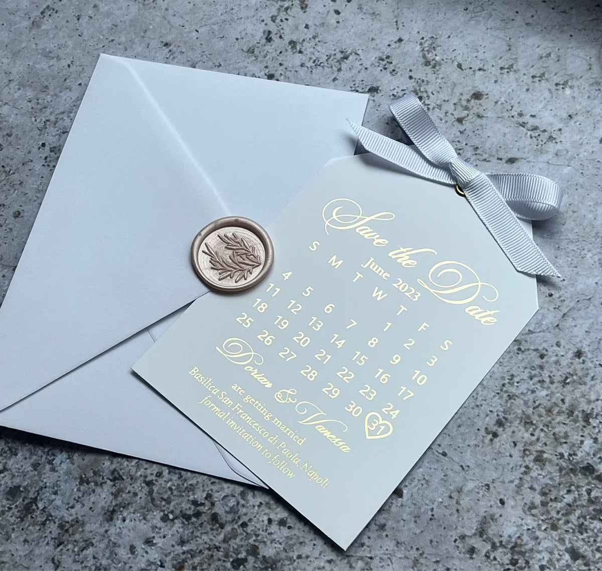 Save the date calendar card with foil lettering and a satin ribbon, a personalized wedding tag with the month and date marked.