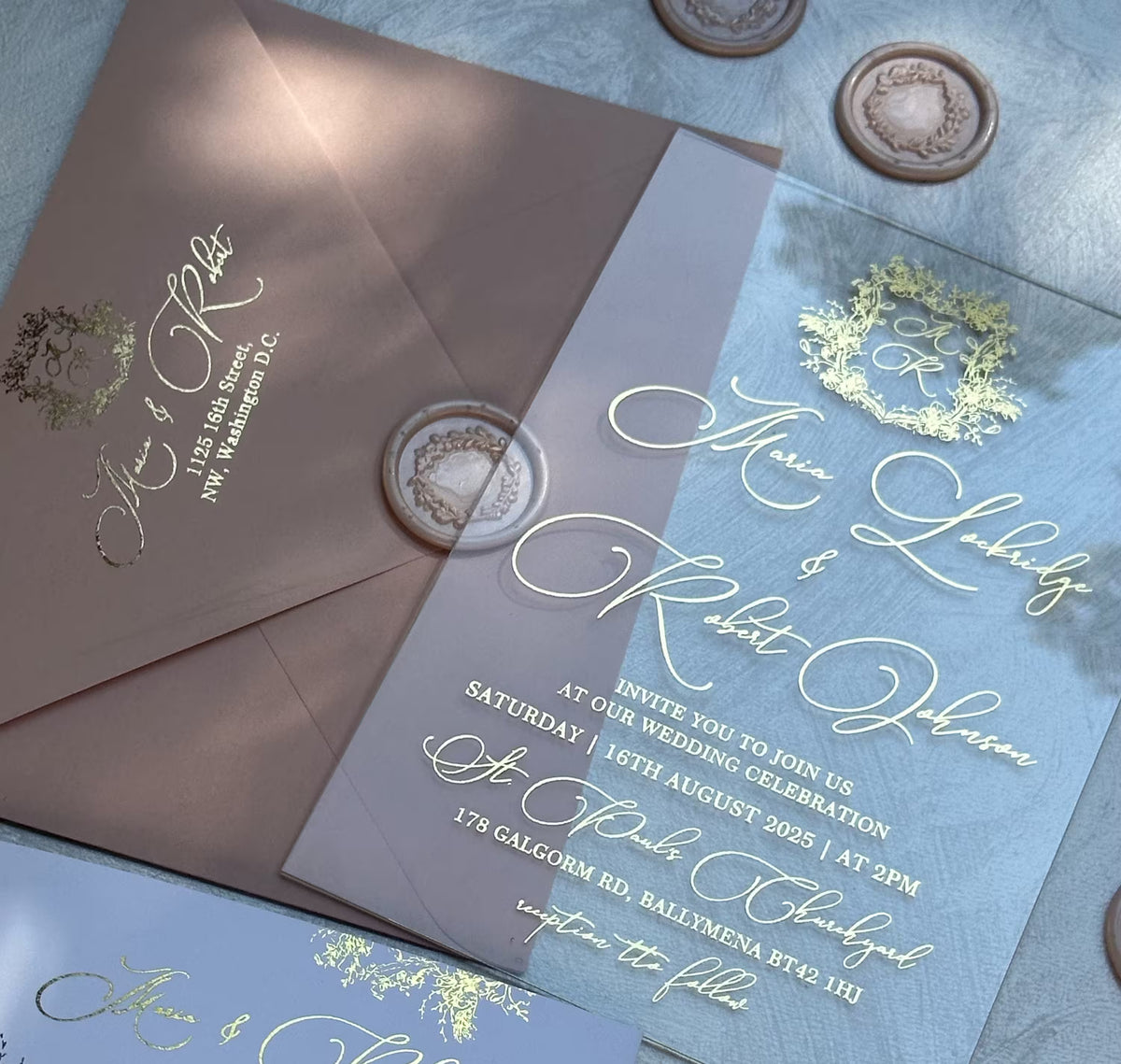 Transparent wedding invitations with floral crest monogram in foil on clear acrylic