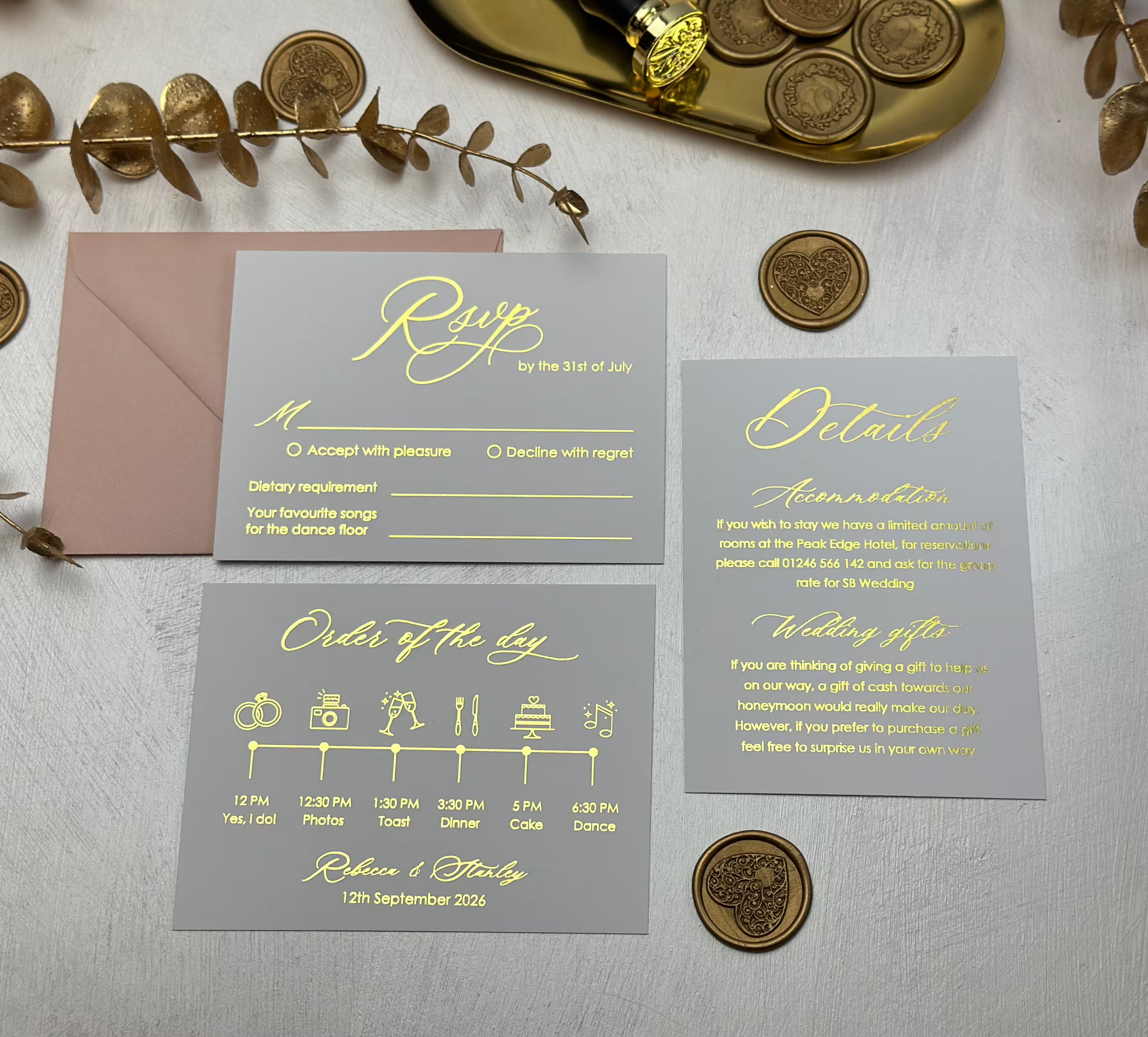 White  RSVP and details cards with gold foil calligraphy and an order of the day timeline beside a blush envelope
