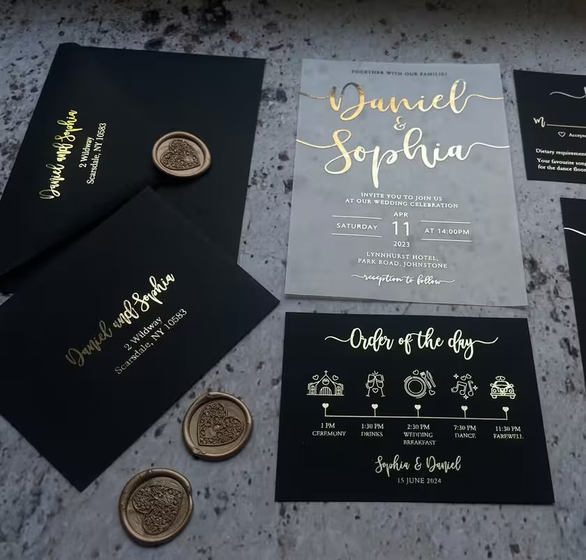 Gold foil vellum wedding invitation with black envelopes, wax seals, and matching order of the day card